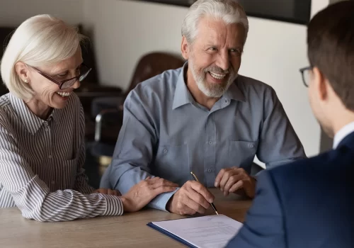 front view of happy elder couple talking with estate lawyer